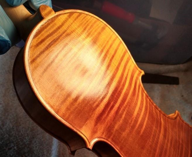 The Strad Making Matters applying the ground coat to a violin The