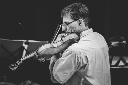 Winfried Vögele tuning a violin