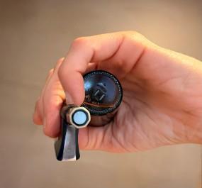 The hand holding a small bottle: the dome visible from above, the cylinder of inner space naturally preserved.